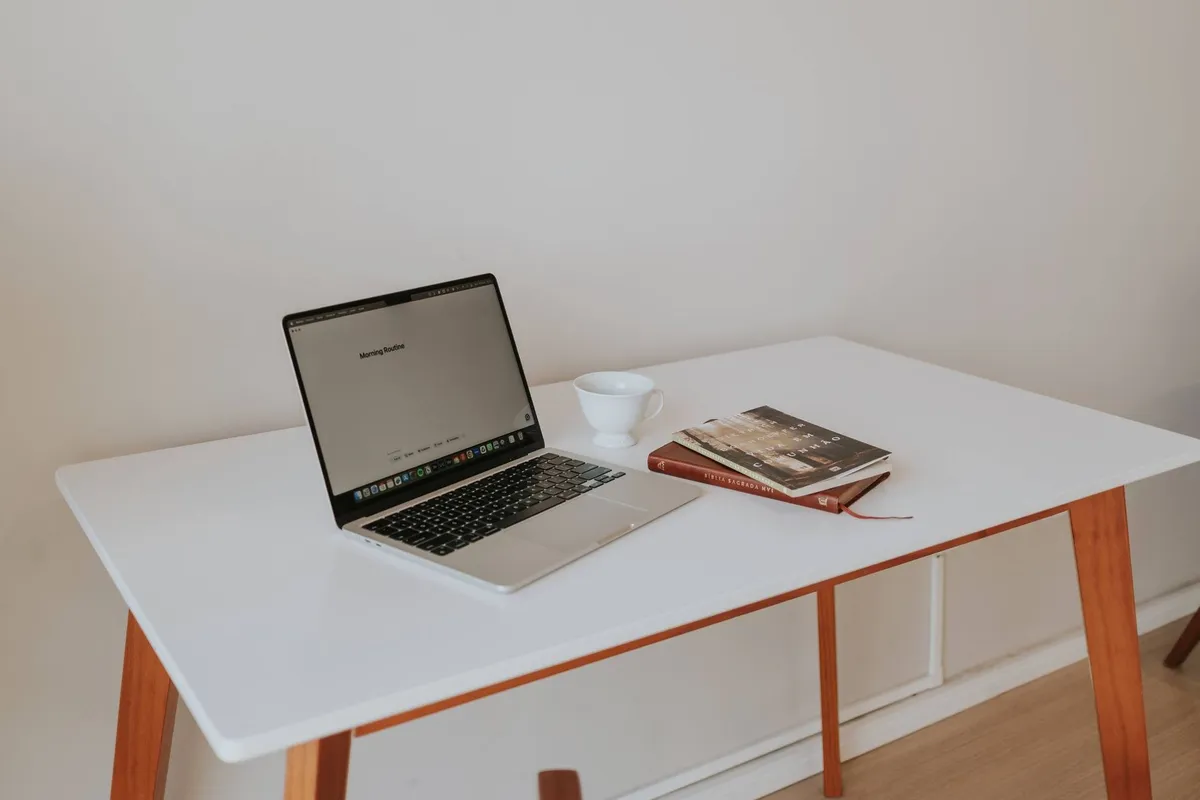 A minimalistic workspace with a laptop, coffee cup, and books, reflecting a professional approach to local SEO.